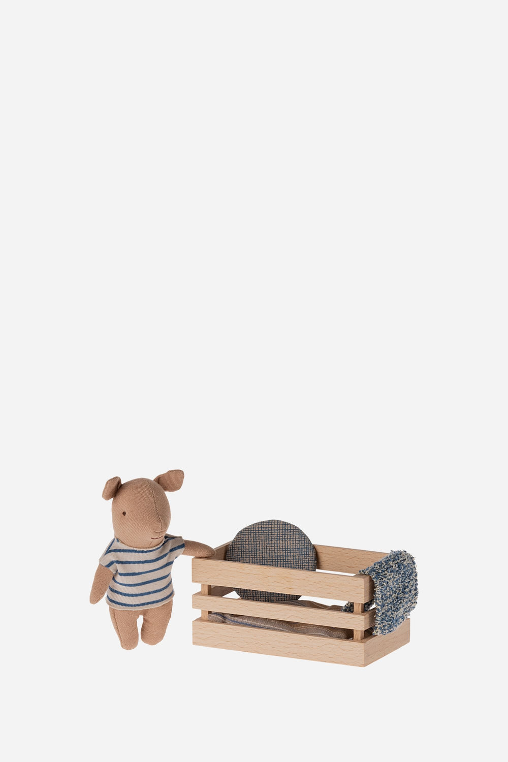 Baby pig in striped blue shirt next to box