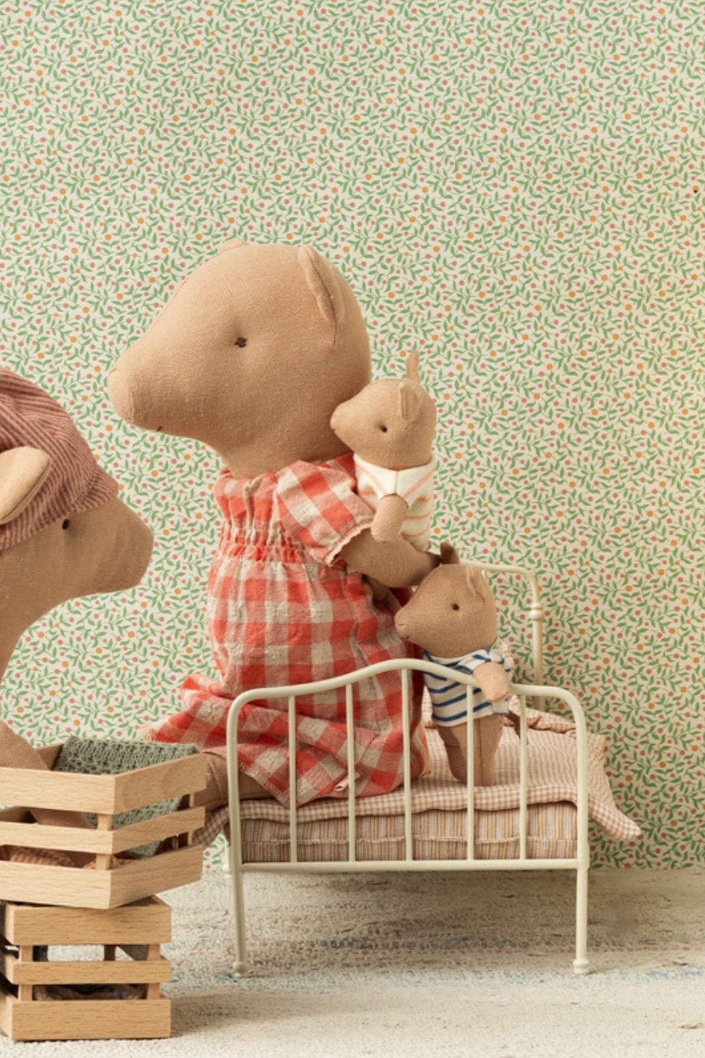 Stuffed pigs in a bedroom setting with floral wallpaper