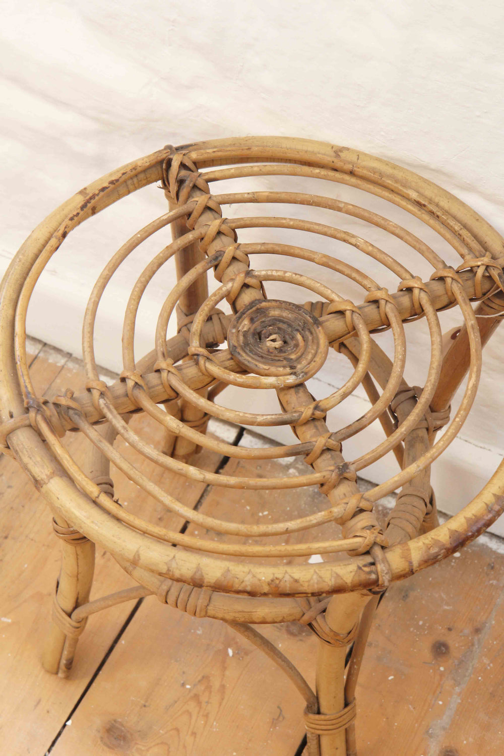 Wicker chair on a wooden floor with a white wall background