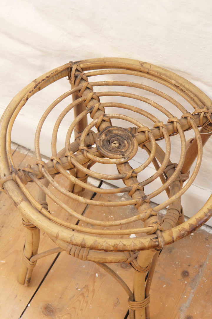 Wicker chair on a wooden floor with a white wall background