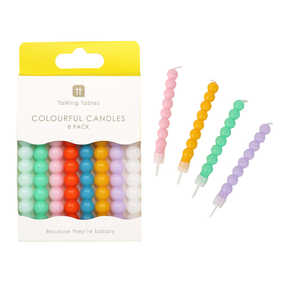 Packaged colourful bobbly candles with a sample outside the packaging on a white background.