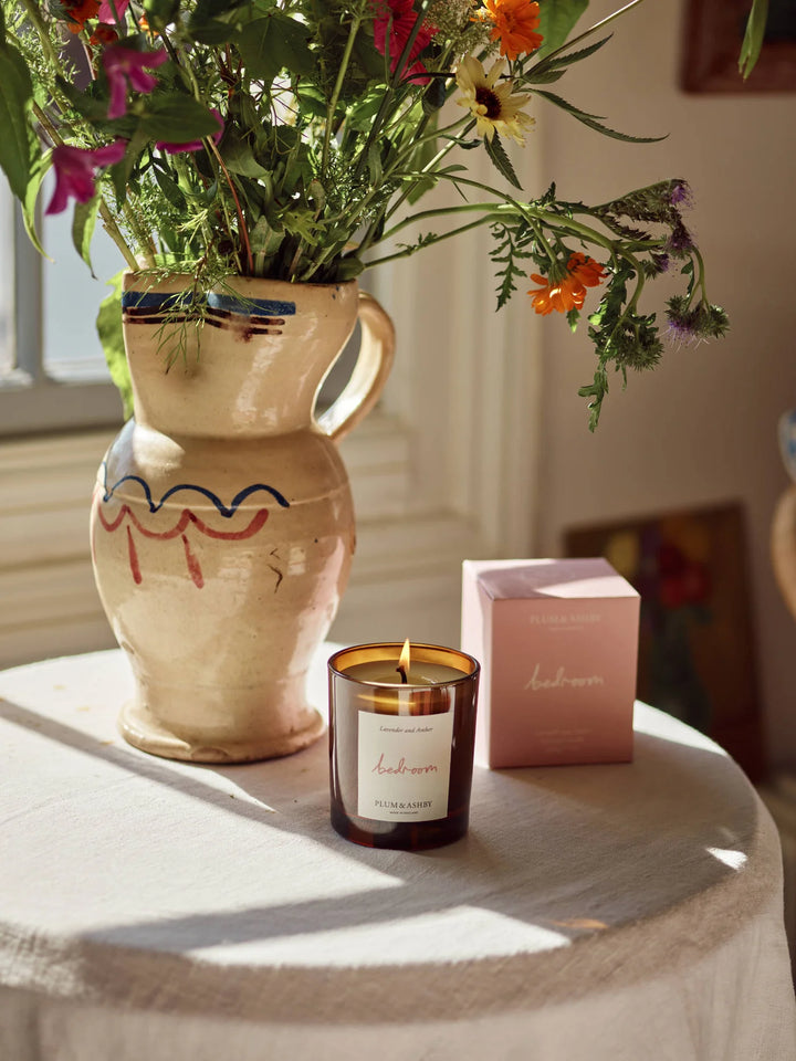 Candle Bedroom Lavender & Amber on linen covered table with flowers