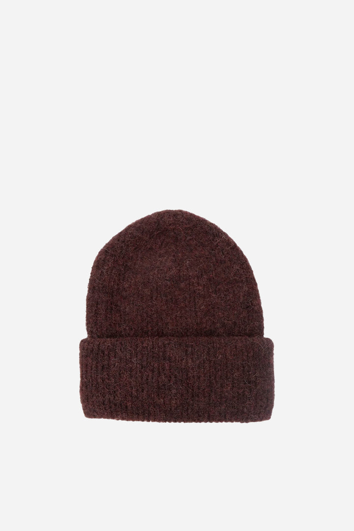 Brown knit beanie on a light beige background