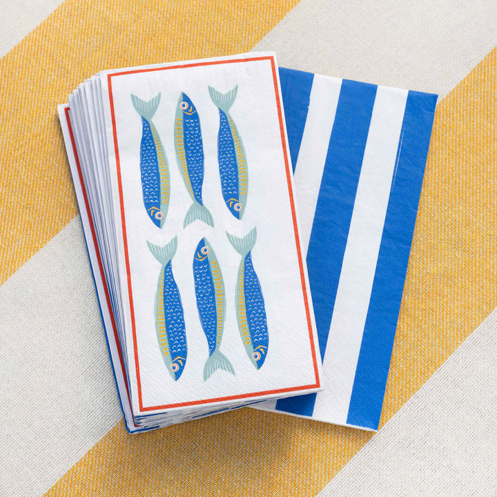 Stack of napkins with fish design on a striped yellow and white background