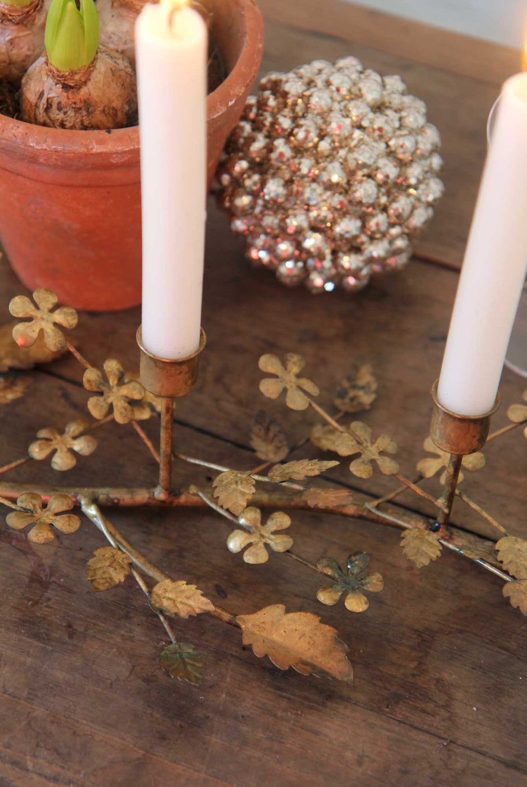 Decorative candle holder with candles on a wooden surface with decorative elements.