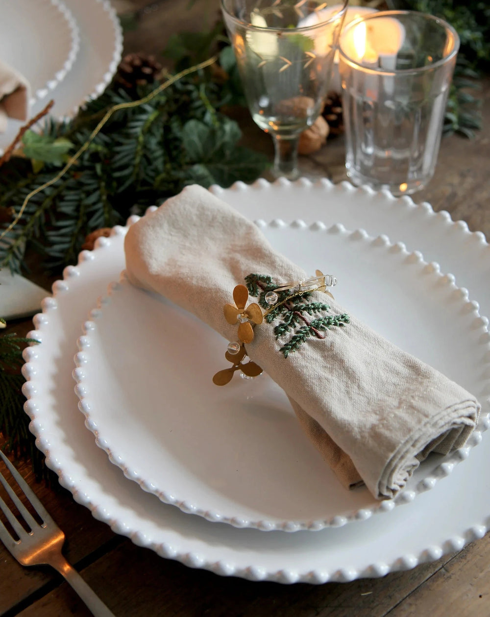 brass flower napkin ring with white beads on Christmas table