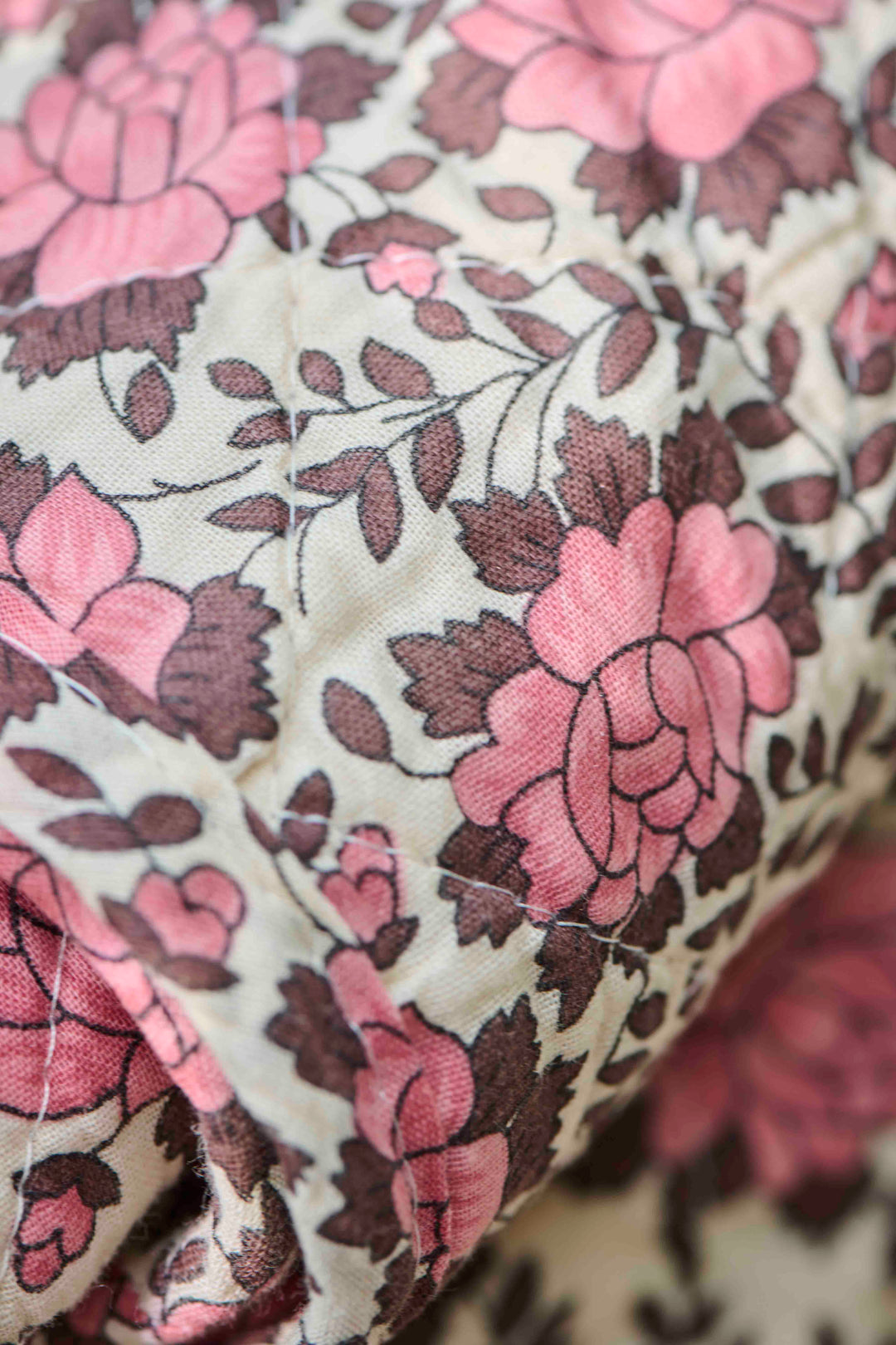 close up detail of brown and pink floral quilt