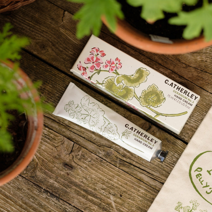 C. Atherley hand cream packaging on a wooden surface with plants around