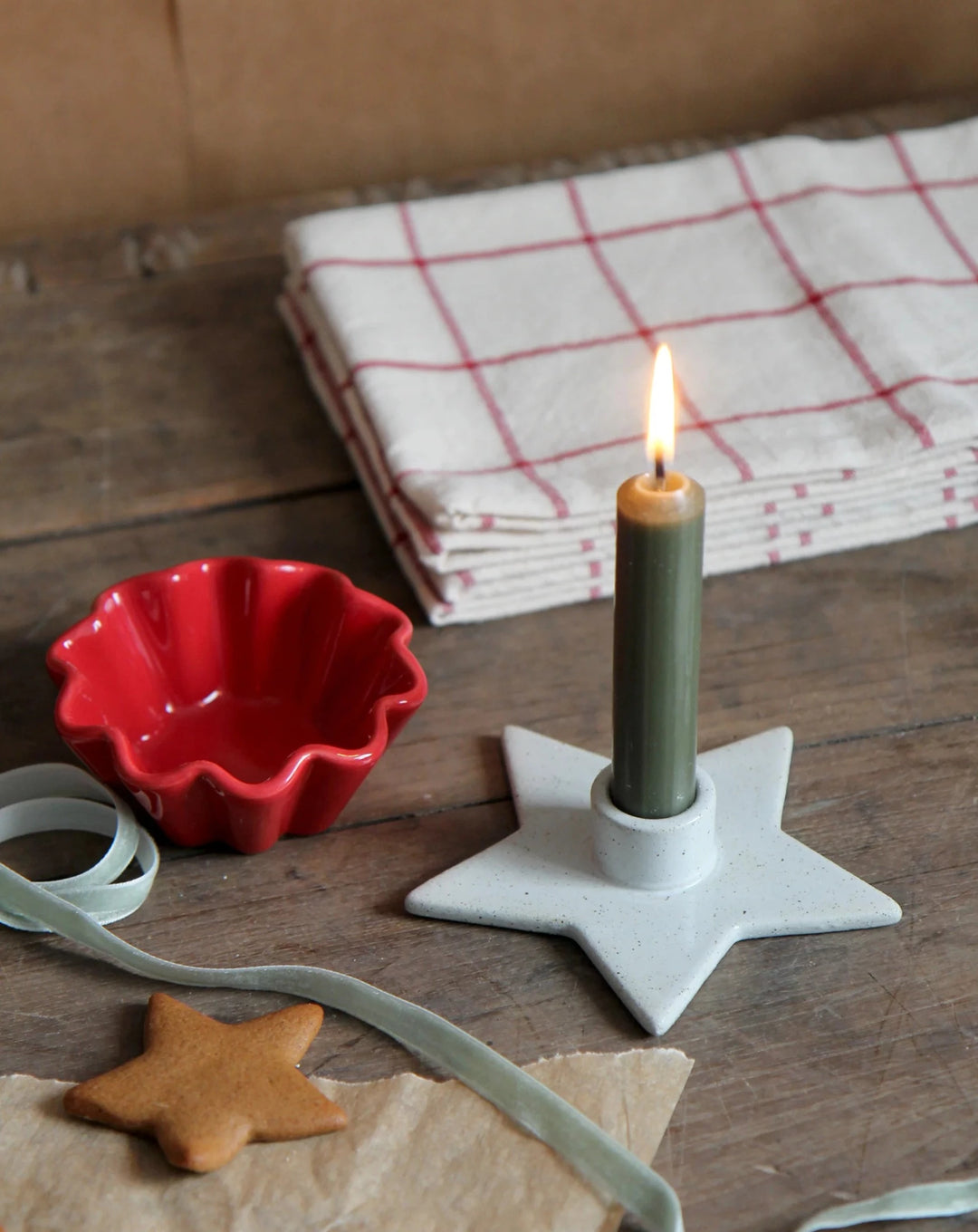 christmas star candle holder with forest green dinner candle, velvet ribbon and Christmas gingerbread