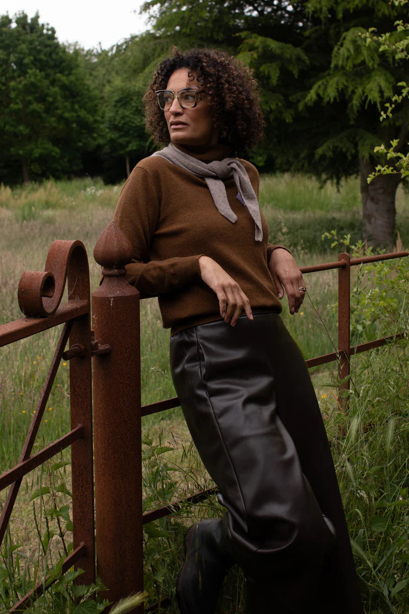 Woman standing by a rustic fence in a natural setting