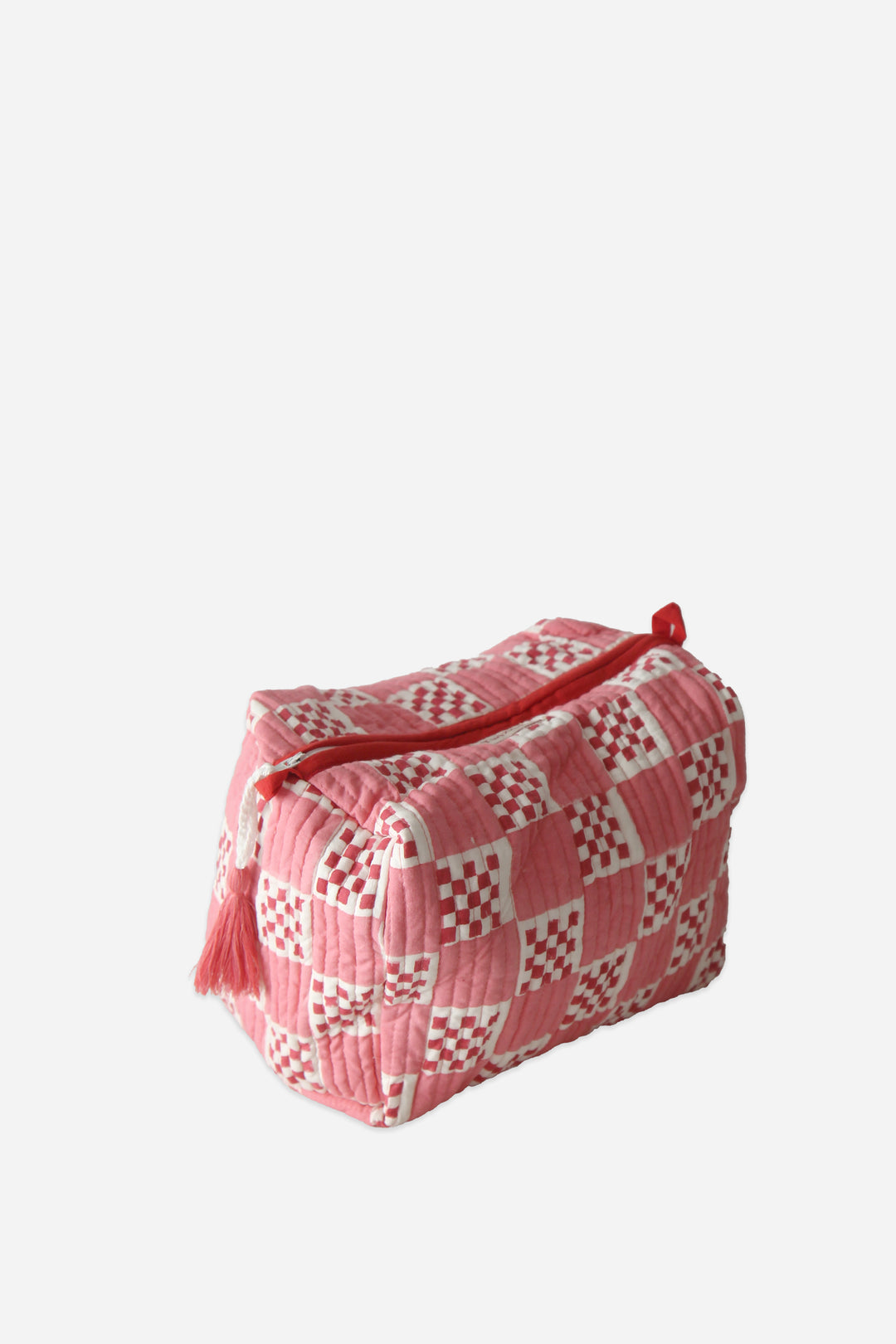 Pink and white patterned toiletry bag on a light gray background