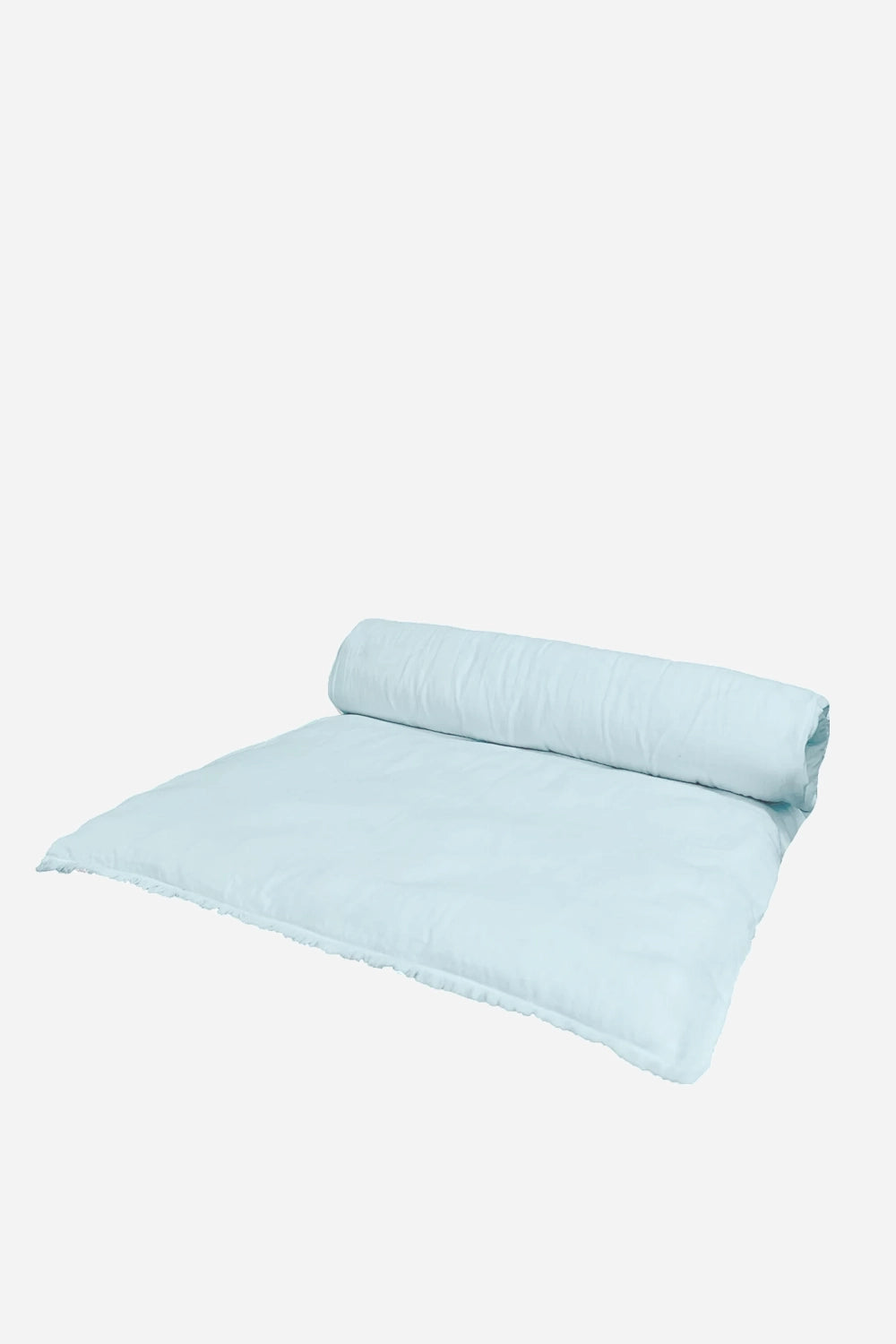 Light blue quilt rolled up on a white background