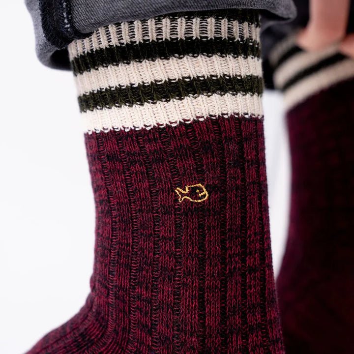 Maroon sock with a gold fish emblem on a white background