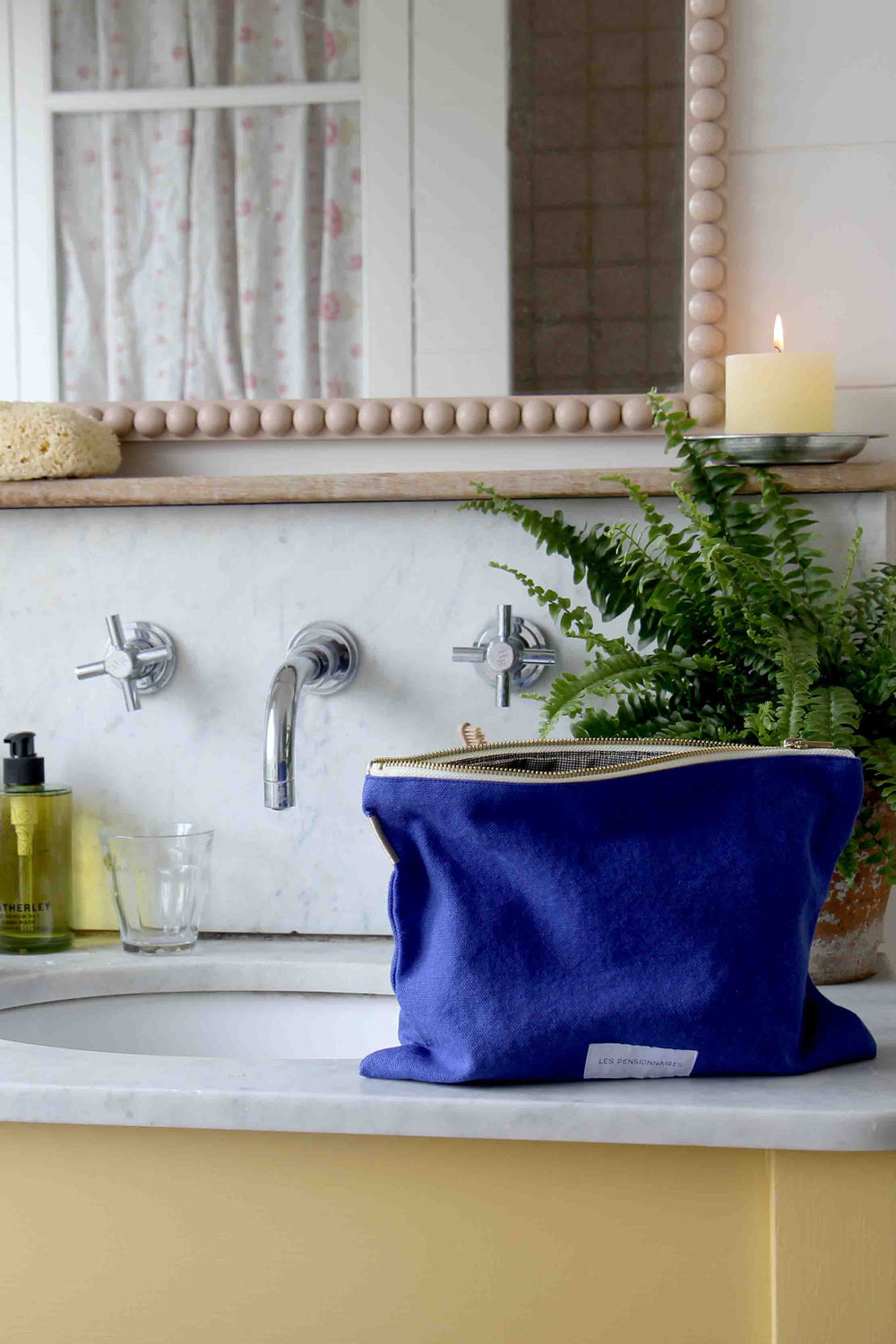les pensionnaires cobalt toiletry bag in yellow bathroom