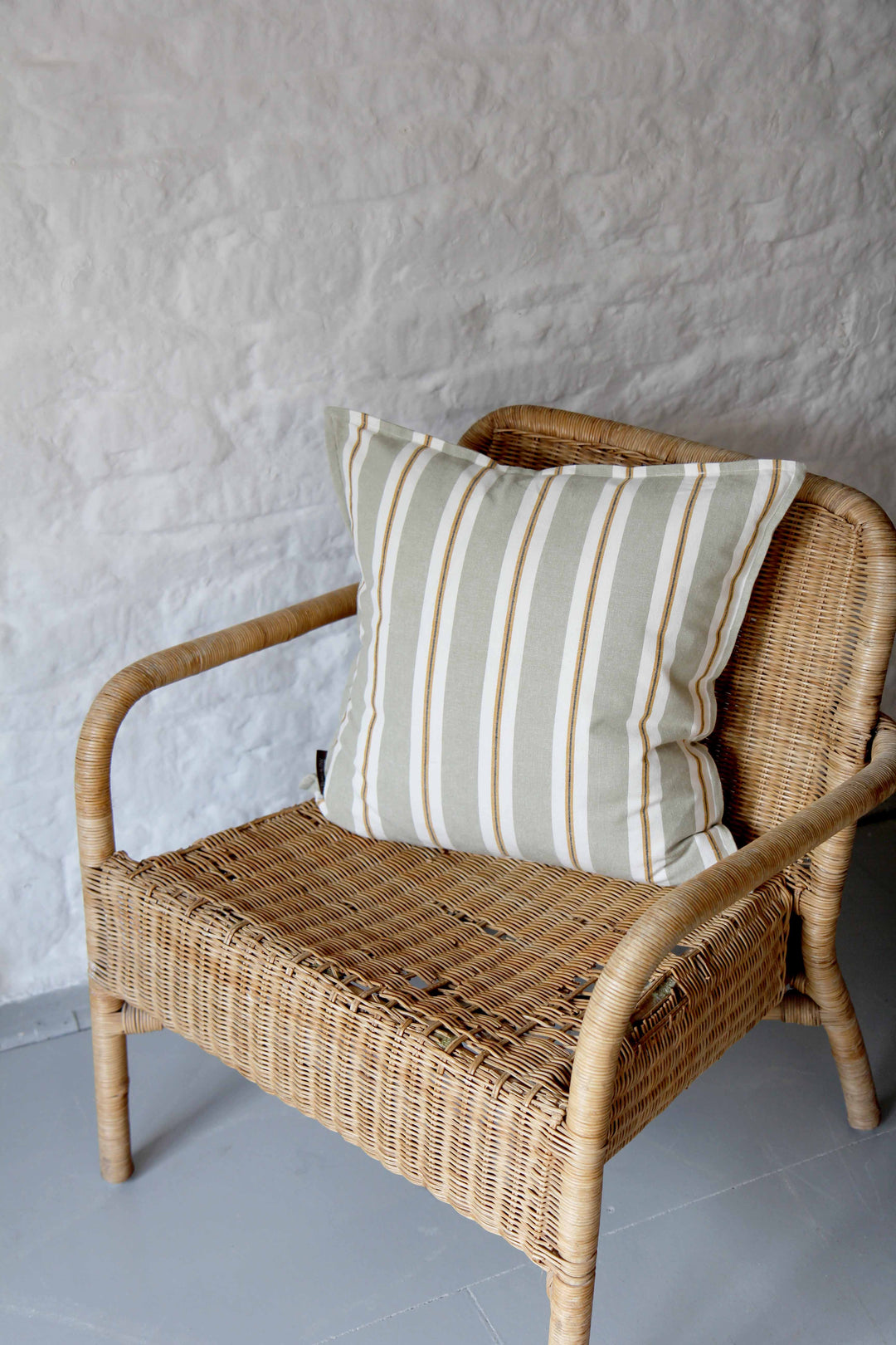 sage striped cotton garden cushion on rattan chair