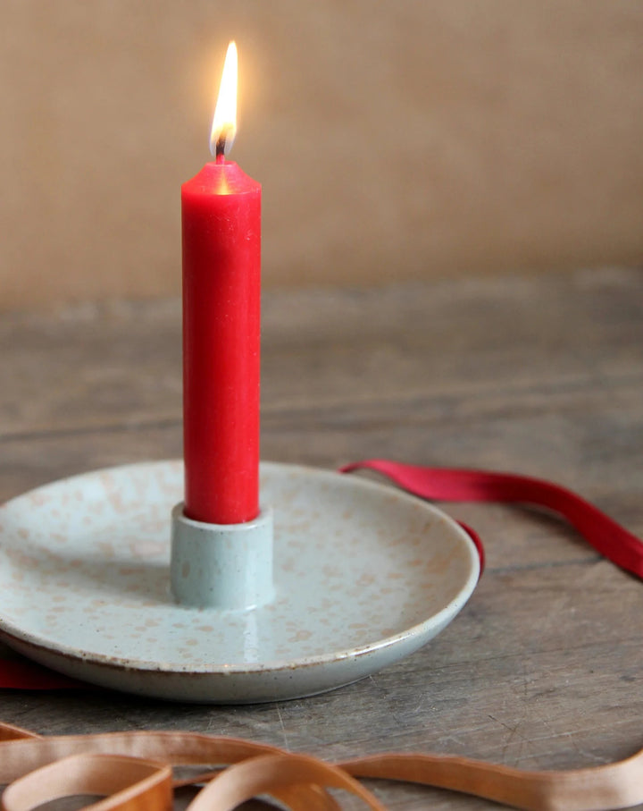 dappled green ceramic candle holder with red christmas dinner candle burning