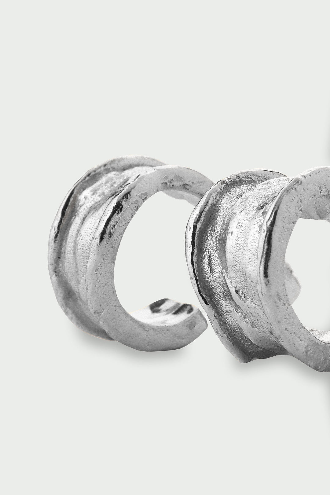 Silver earrings on a light gray background