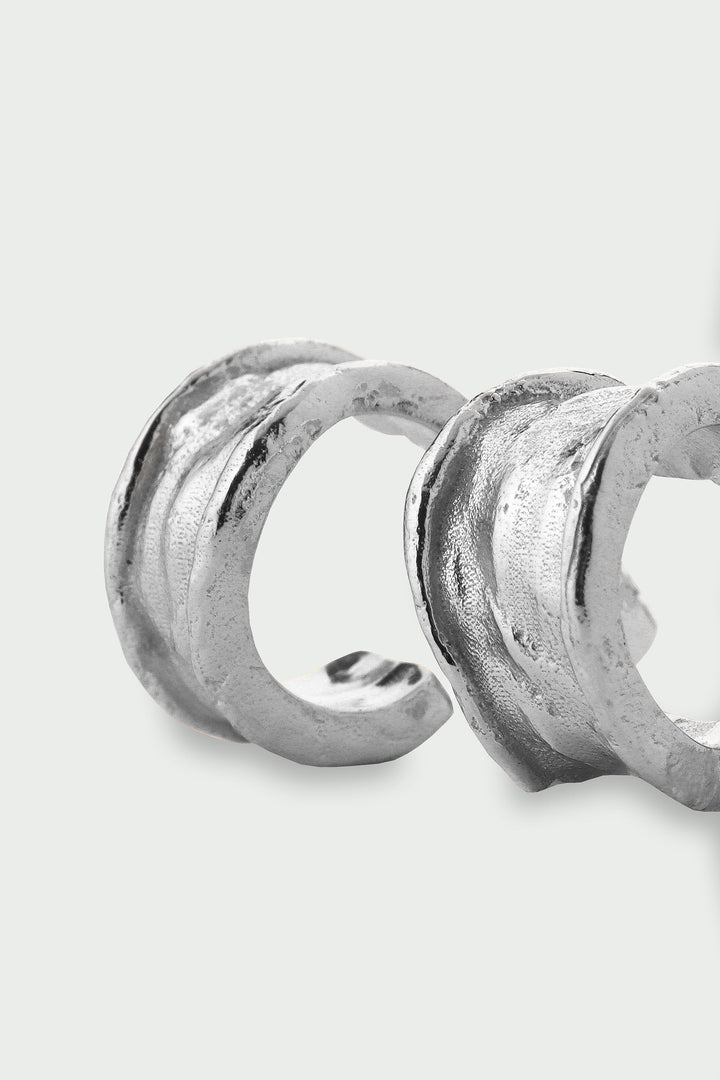 Silver earrings on a light gray background