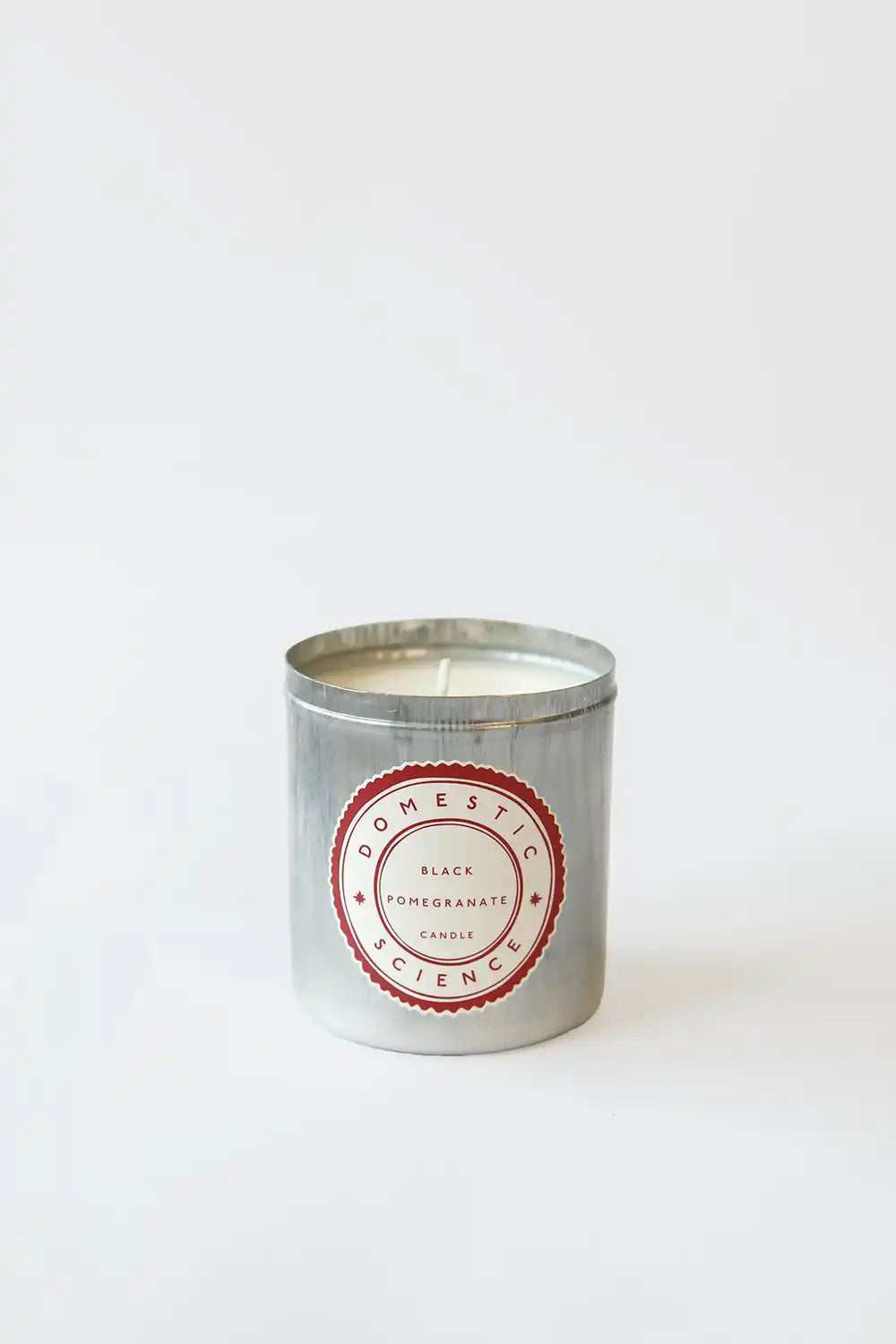 Candle in a tin with a red label on a white background