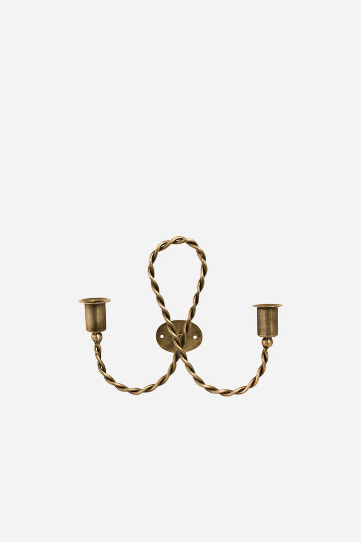 Brass wall sconce with two candle holders on a white background