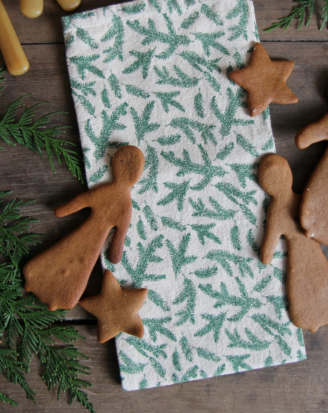 christmas t-towel with fir branch print, pictured with fir tree and gingerbread scandi christmas