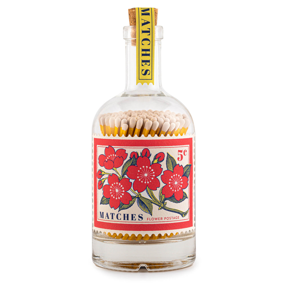 glass bottle filled with matches with decorative floral postage stamp lable