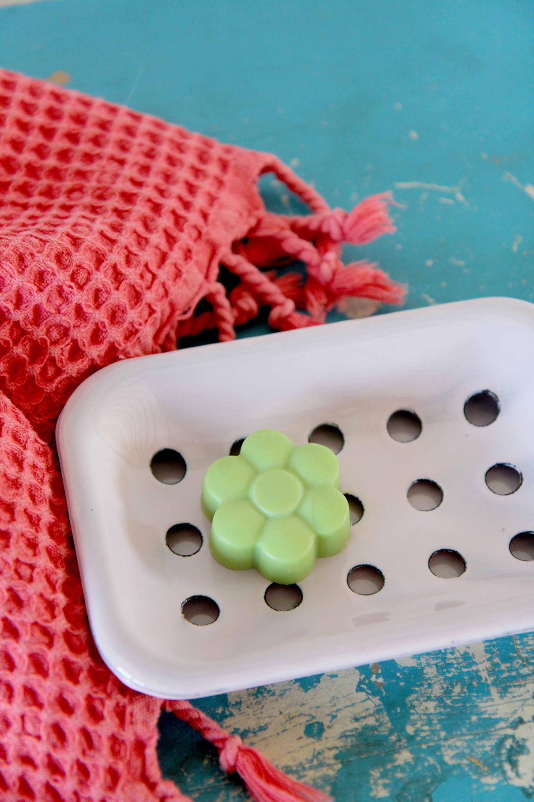 green flower soap on pink enamel soap dish