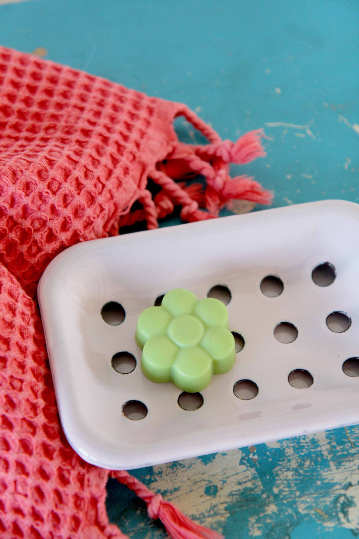 green flower soap on pink enamel soap dish