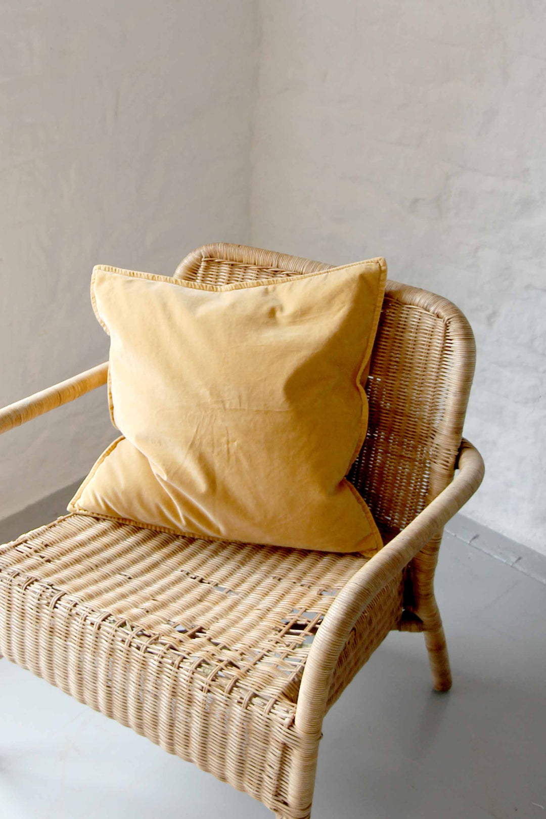 harvest yellow velvet square cushion on rattan chair