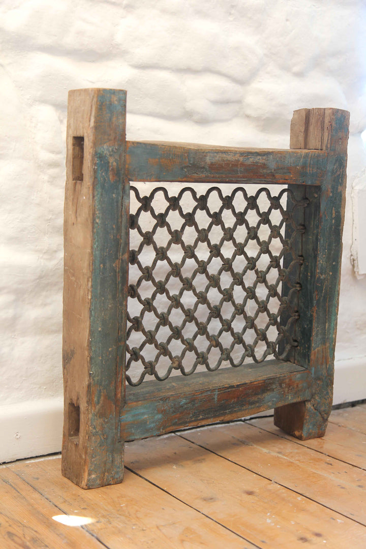 Wooden radiator cover with decorative lattice design on a wooden floor.