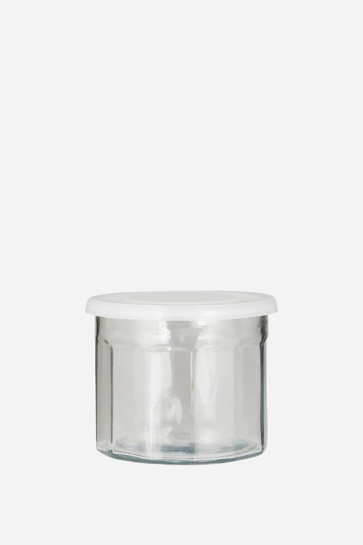 Clear glass jar with a white lid on a white background