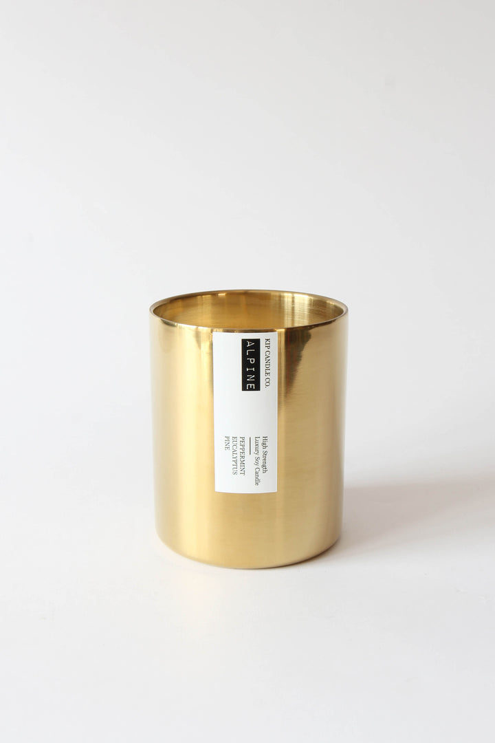 Gold candle holder with a label on a white background
