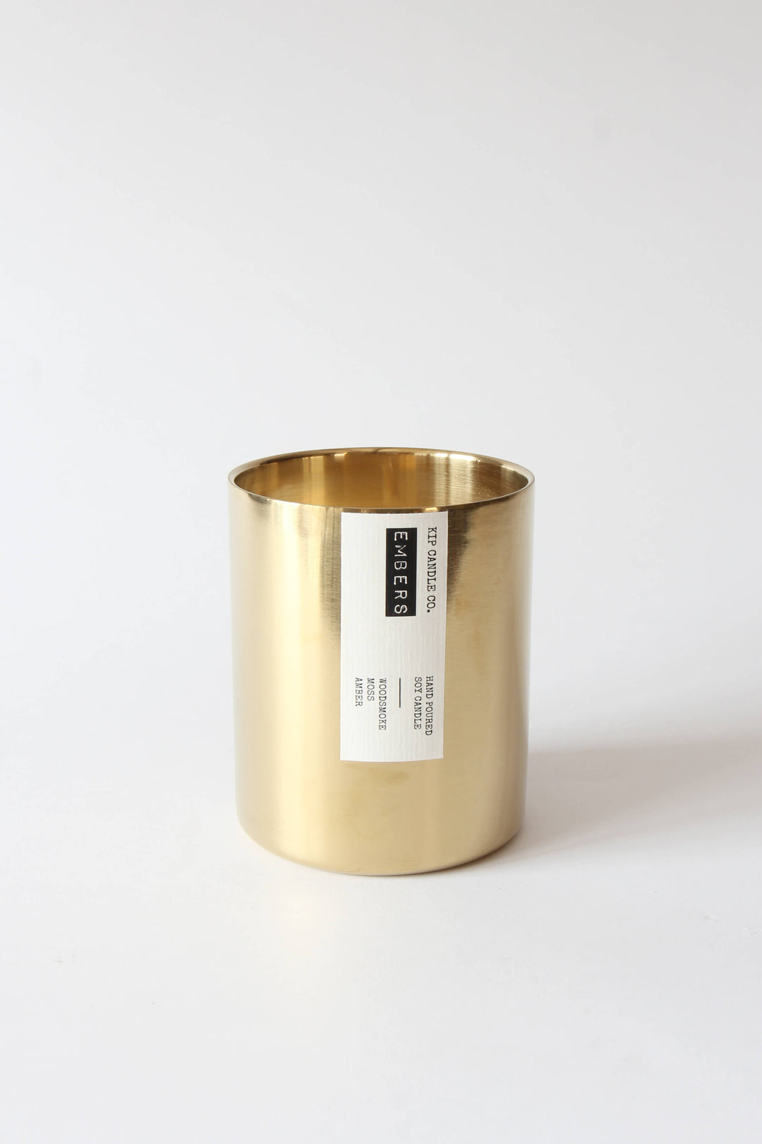 Gold candle holder with a label on a white background