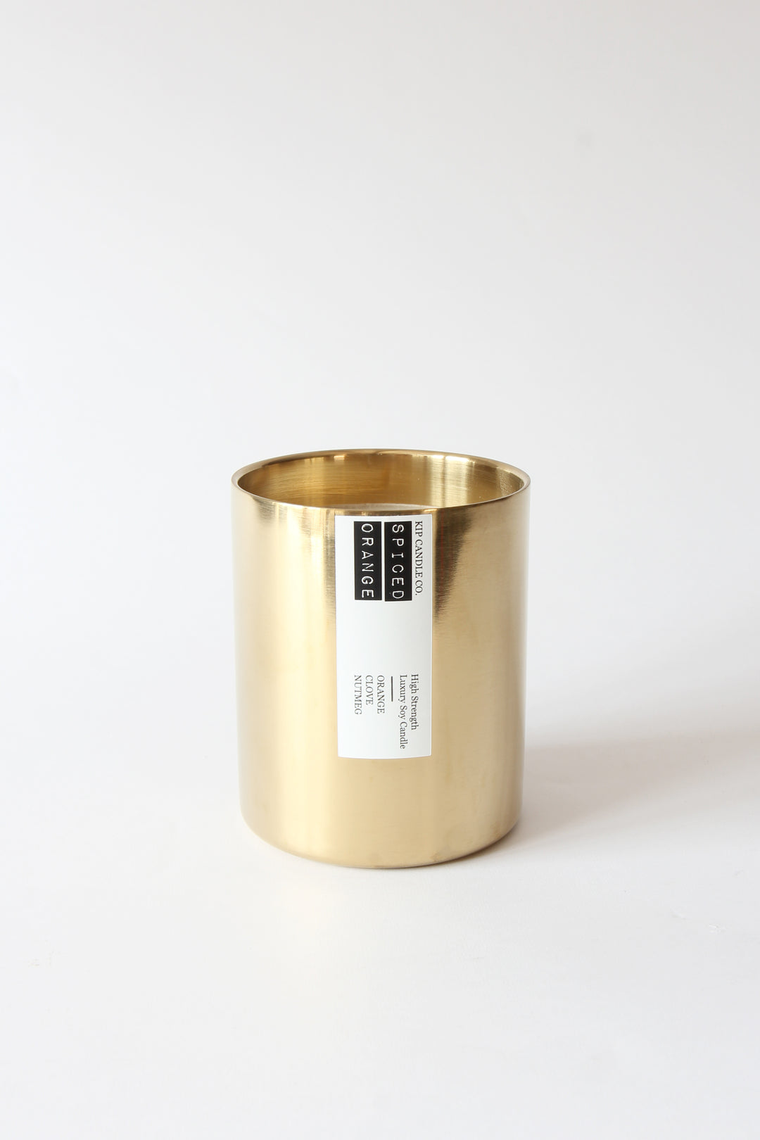Gold candle holder with a label on a white background