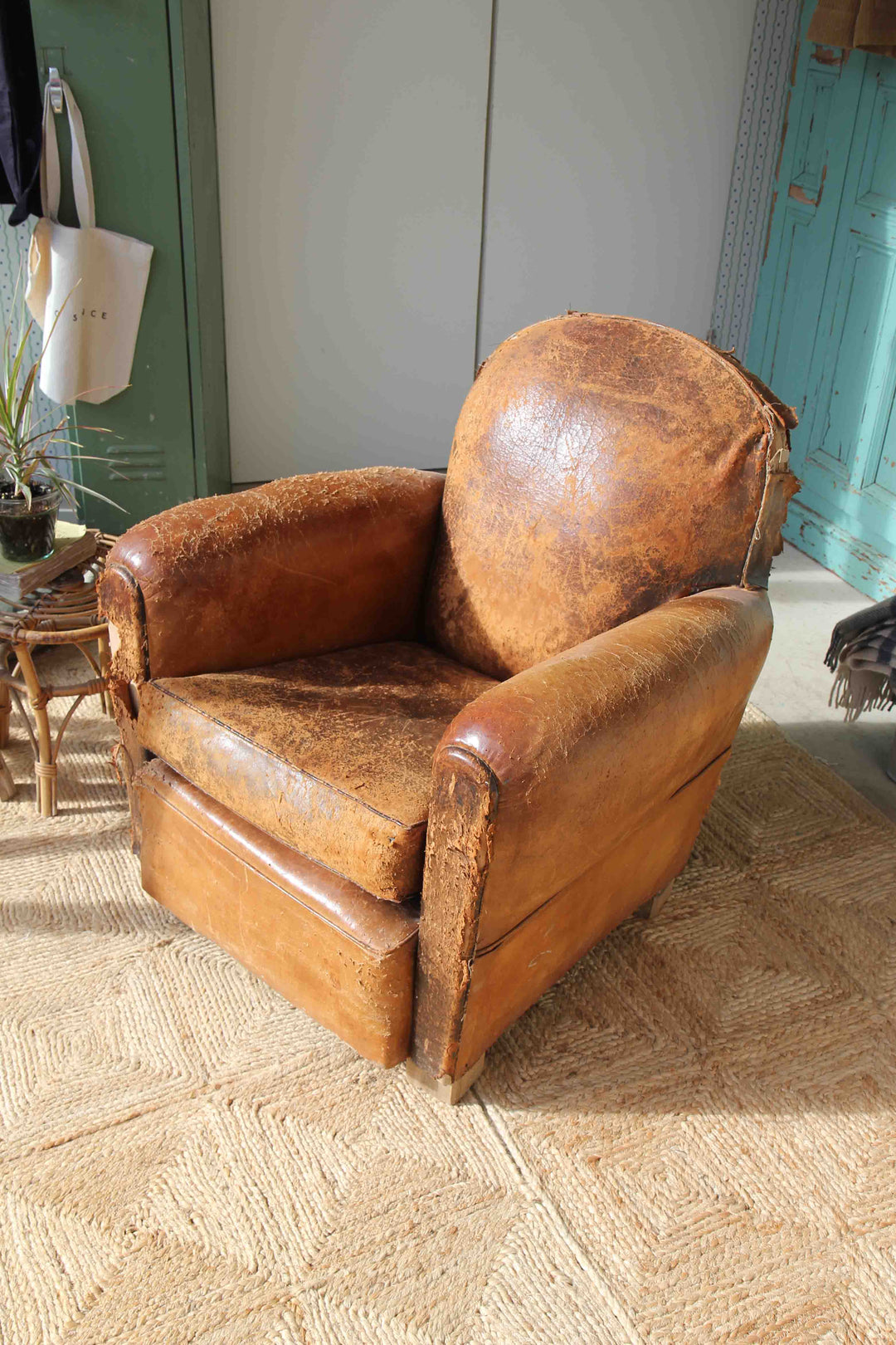 Vintage brown leather armchair on a textured floor with a neutral background