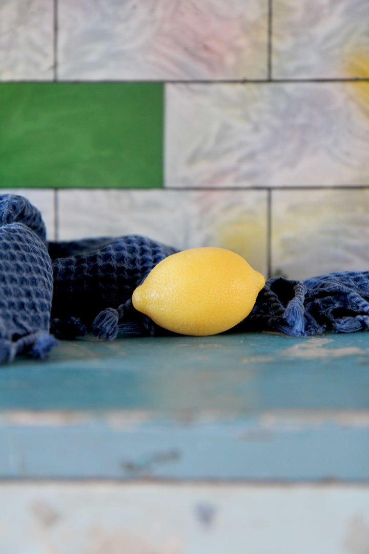 lemon shaped soap and blue waffle towel