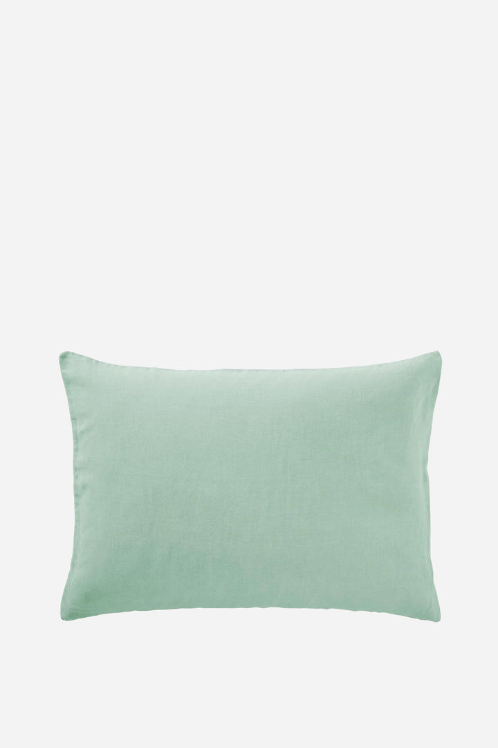 pistachio green linen cushion on light grey background
