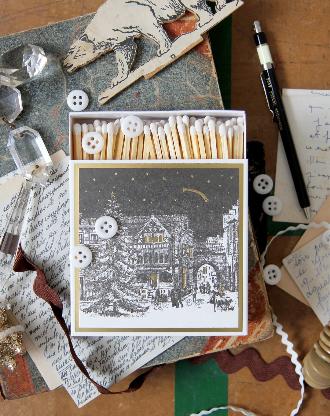 luxury matches featuring a starry night Christmas scene, pictured on a vintage suitcase with buttons and decorations