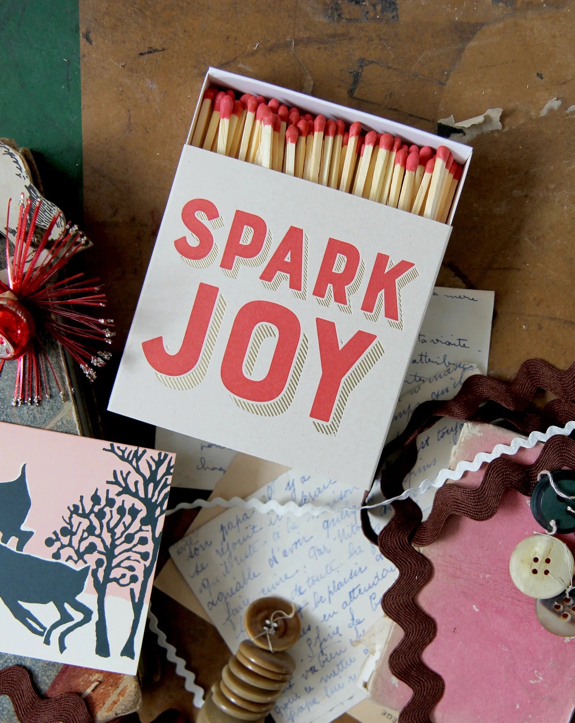 luxury Archivist Spark Joy matches on a vintage suitcase with Christmas ribbons and trims