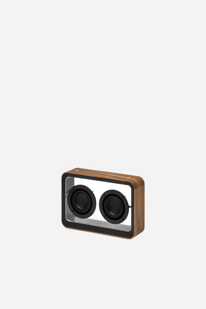 Wooden rectangular speaker with black circular components on a light gray background