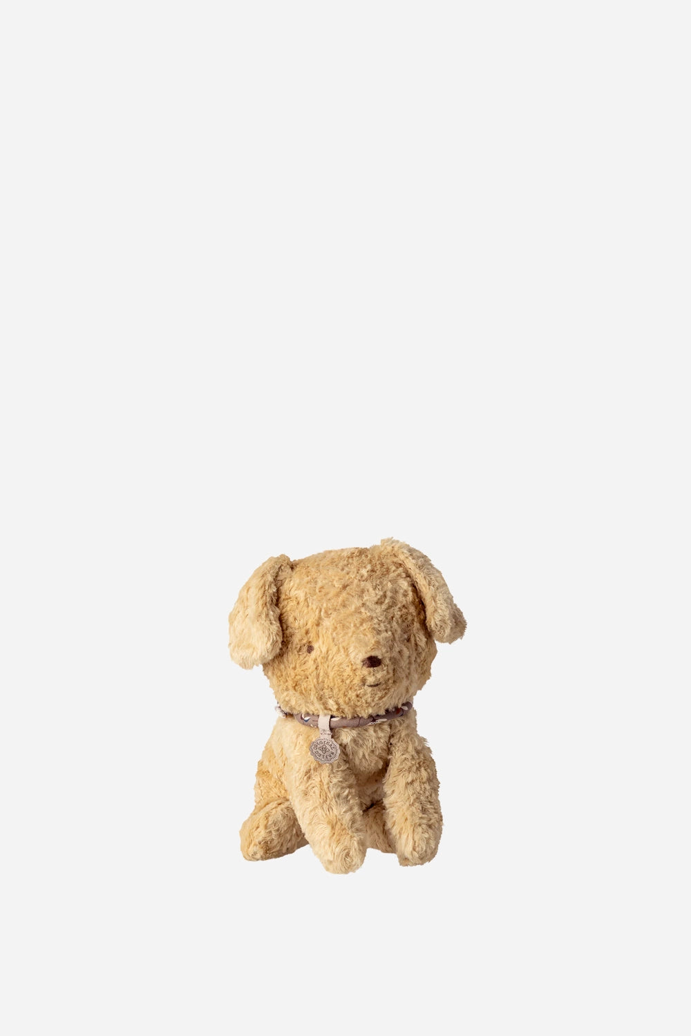 Beige stuffed dog toy on a white background
