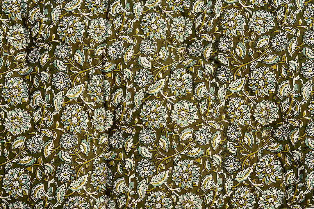 A close-up of a repeating floral pattern with white and light beige flowers, olive green leaves, and stems on a dark olive-brown background.