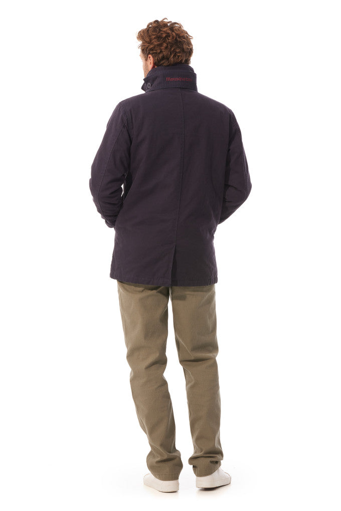 Person wearing a dark jacket and beige pants on a white background