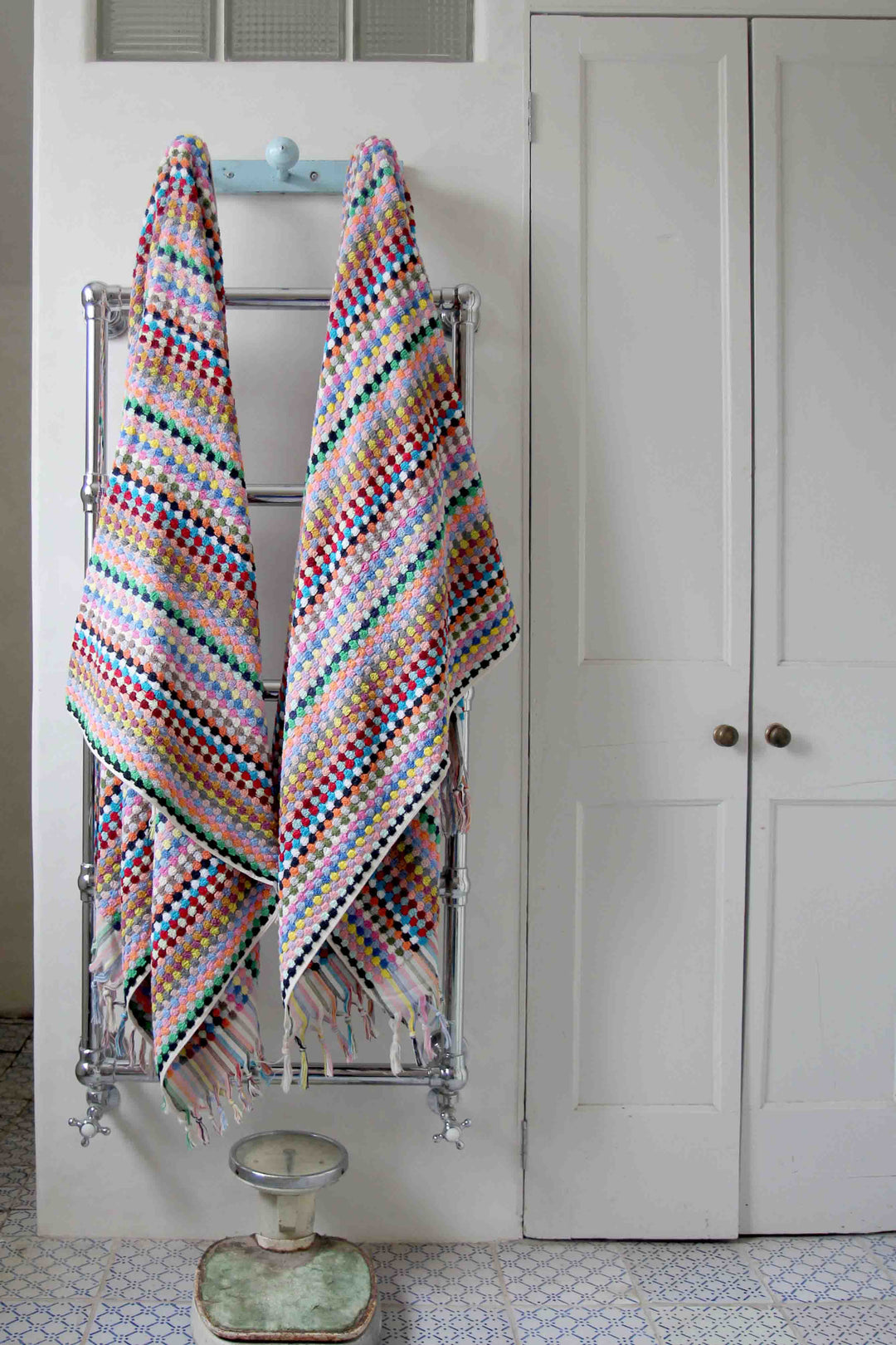 multicoloured spot turkish towels hanging on vintage hooks