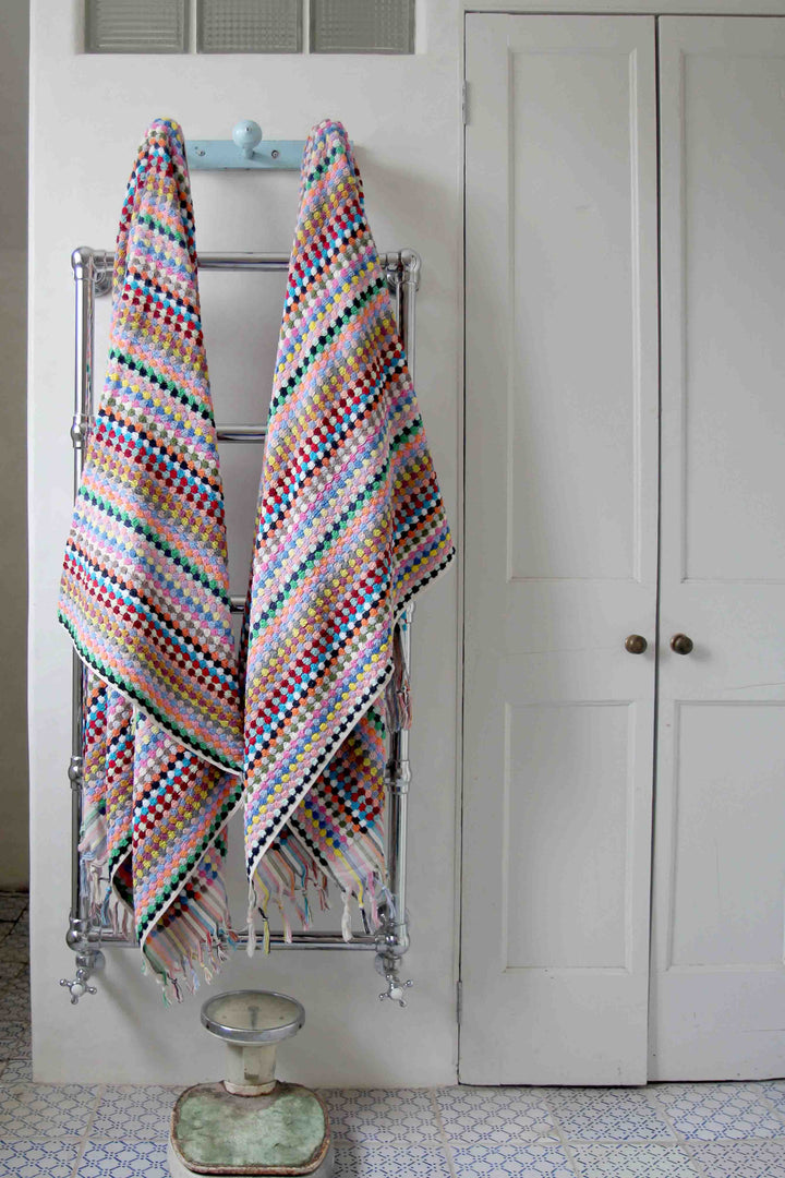 multicoloured spot turkish towels hanging on vintage hooks