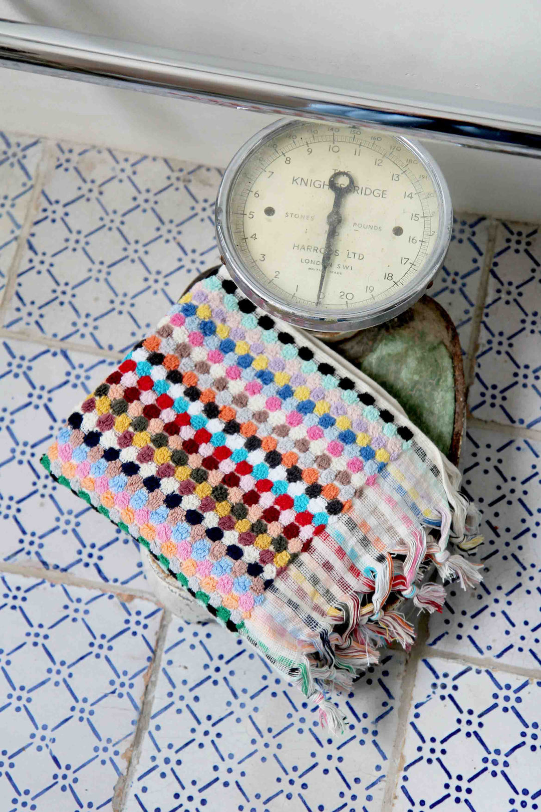 multicoloured spot turkish hand towel on vintage weighing scales