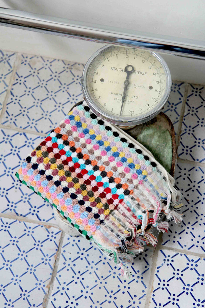 multicoloured spot turkish hand towel on vintage weighing scales