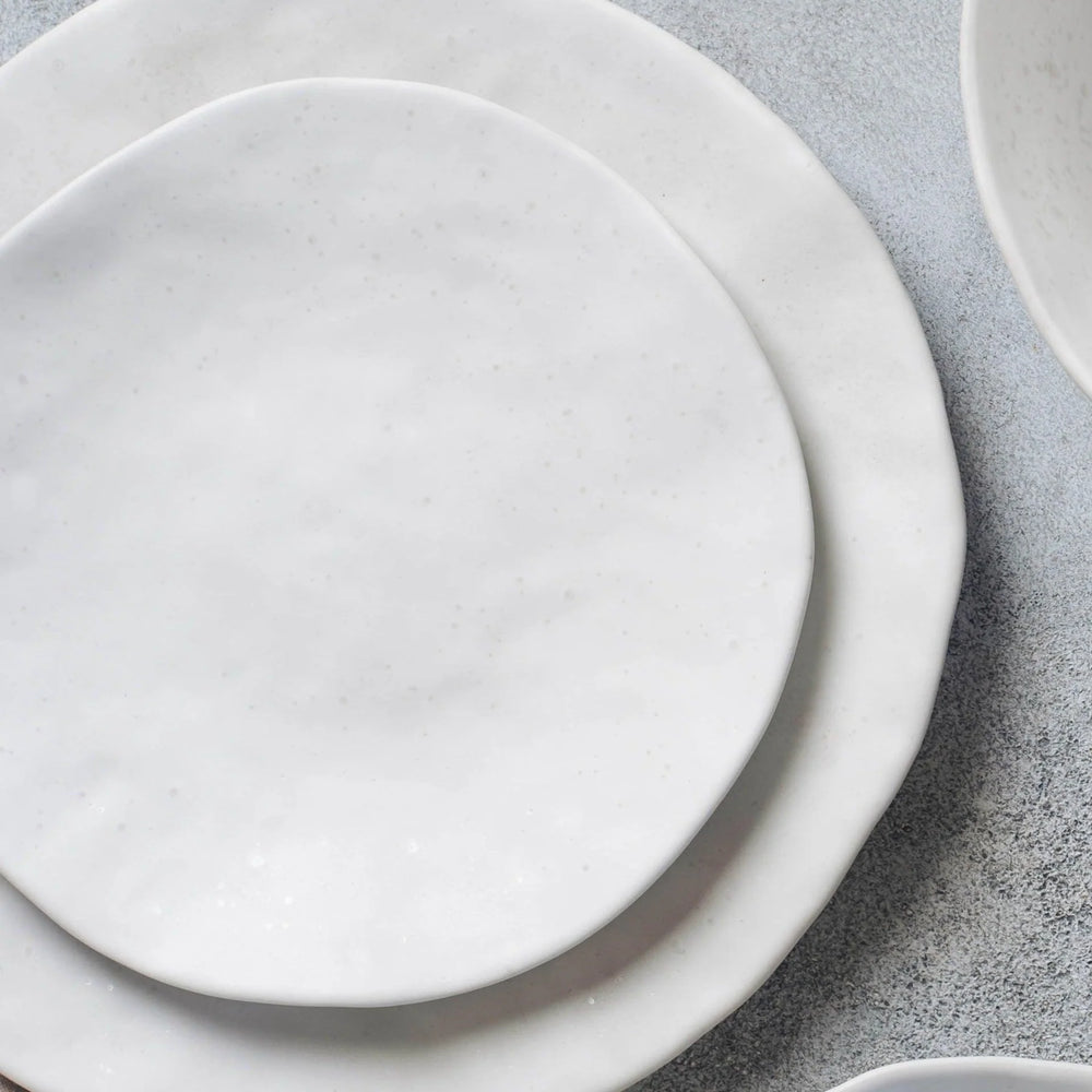 Stack of white ceramic plates on a gray surface