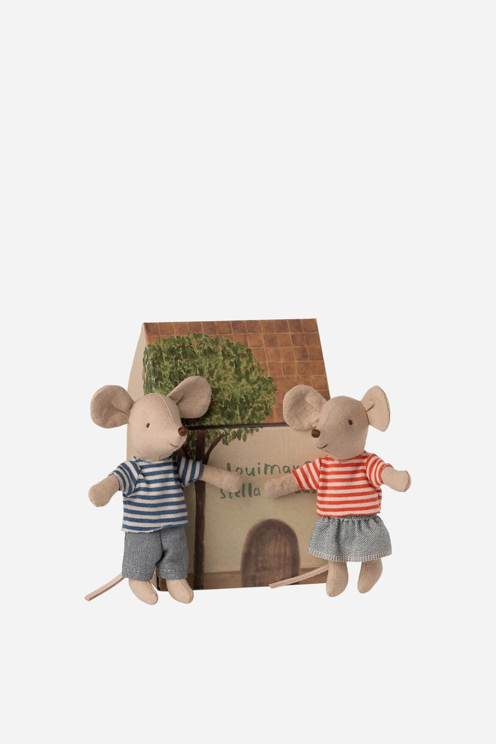 Two toy mice with a small house and tree on a white background