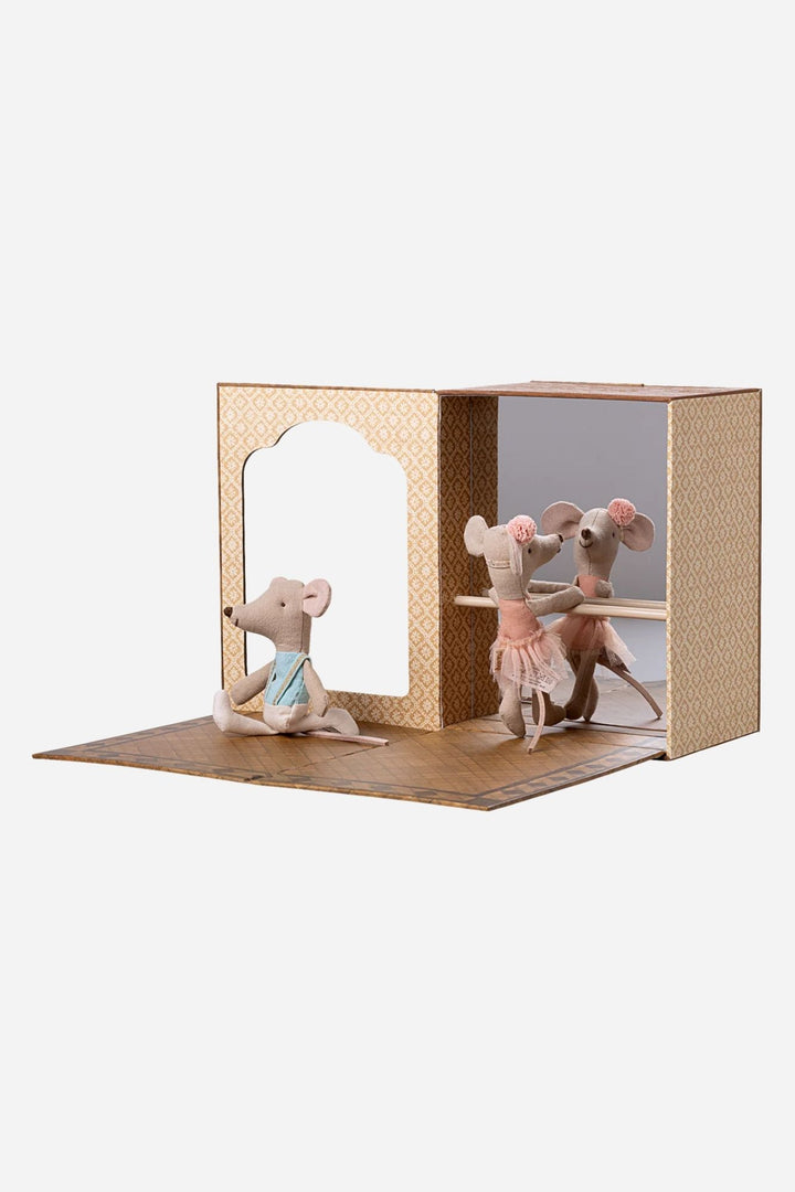 Two toy mice in a small wooden stage with a white background